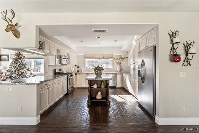 a kitchen with a refrigerator and white cabinets