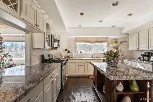 a kitchen with stainless steel appliances granite countertop a stove and a sink
