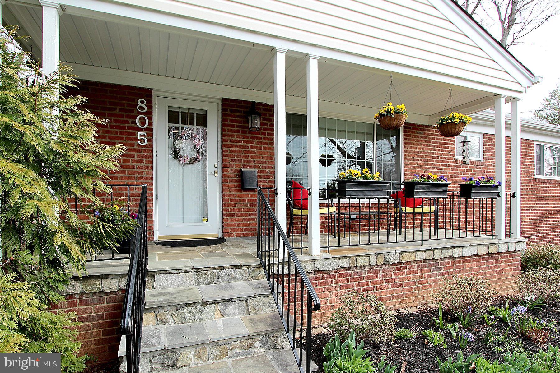 a front view of a house with glass windows and plants