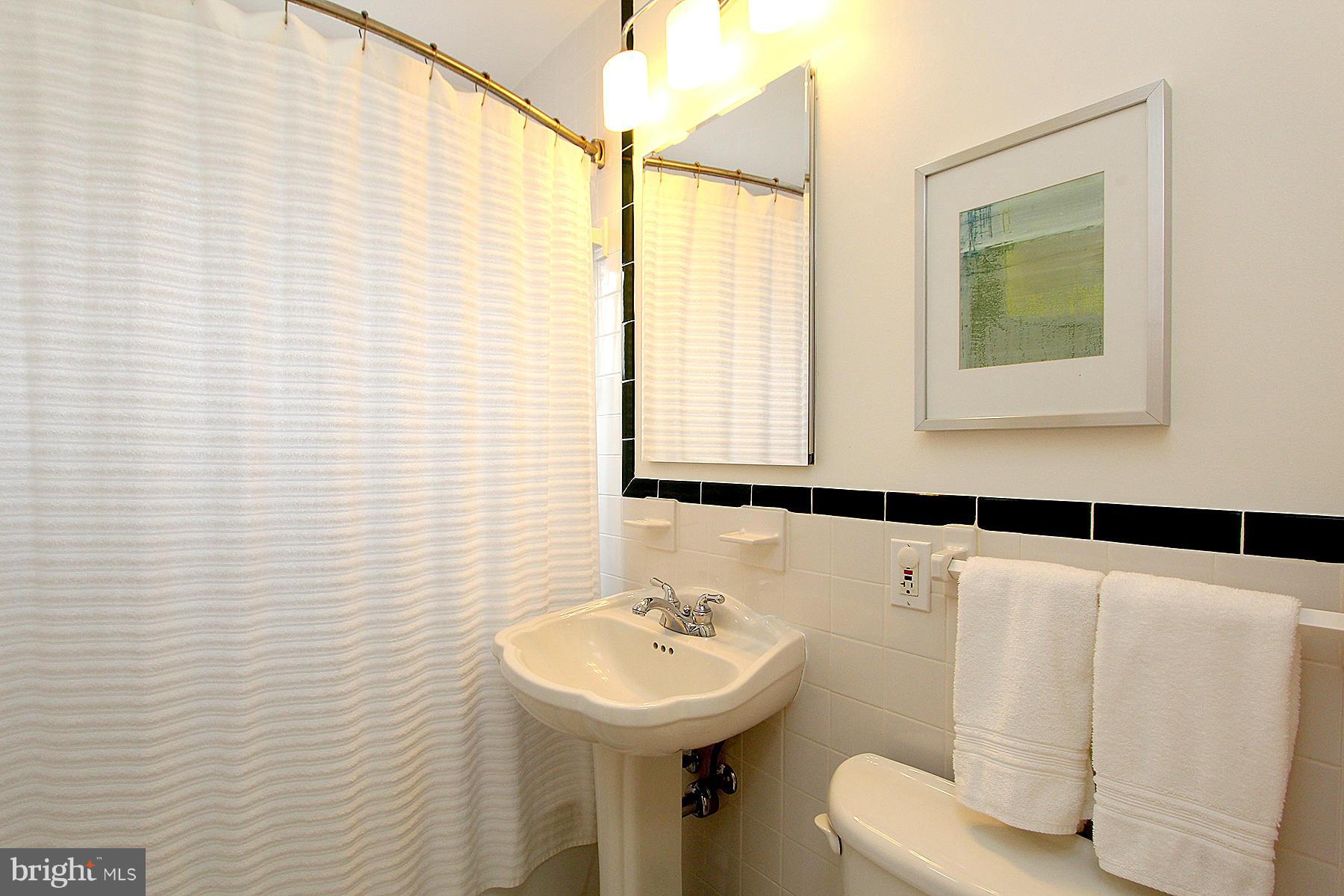 805 Stirling Road Silver Spring, MD 20901 - Photo 21 of 29 a bathroom with a sink a mirror and a shower