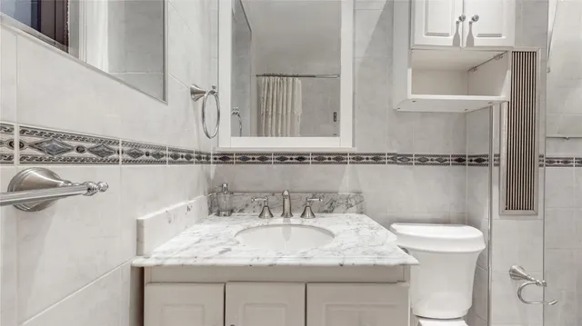 a bathroom with a granite countertop sink a toilet and a mirror