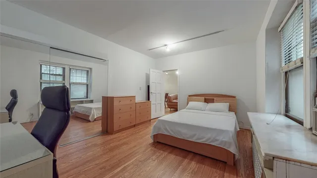 a bedroom with a bed and wooden floor