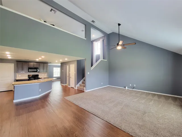 a view of a kitchen with a sink wooden floor and a living room