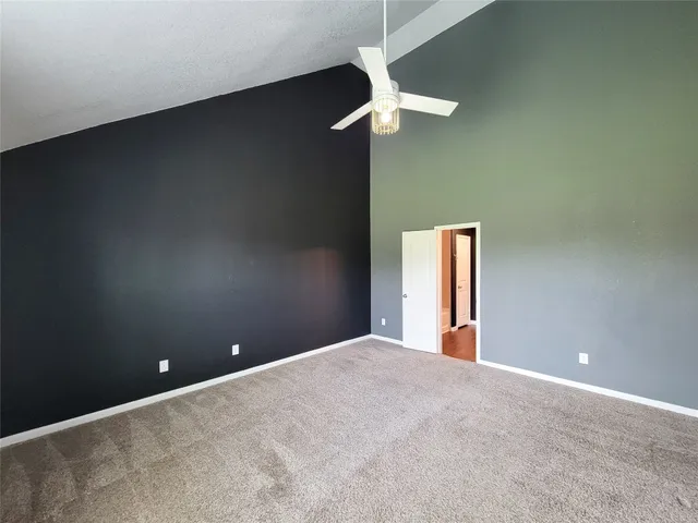 a view of an empty room with a chandelier fan