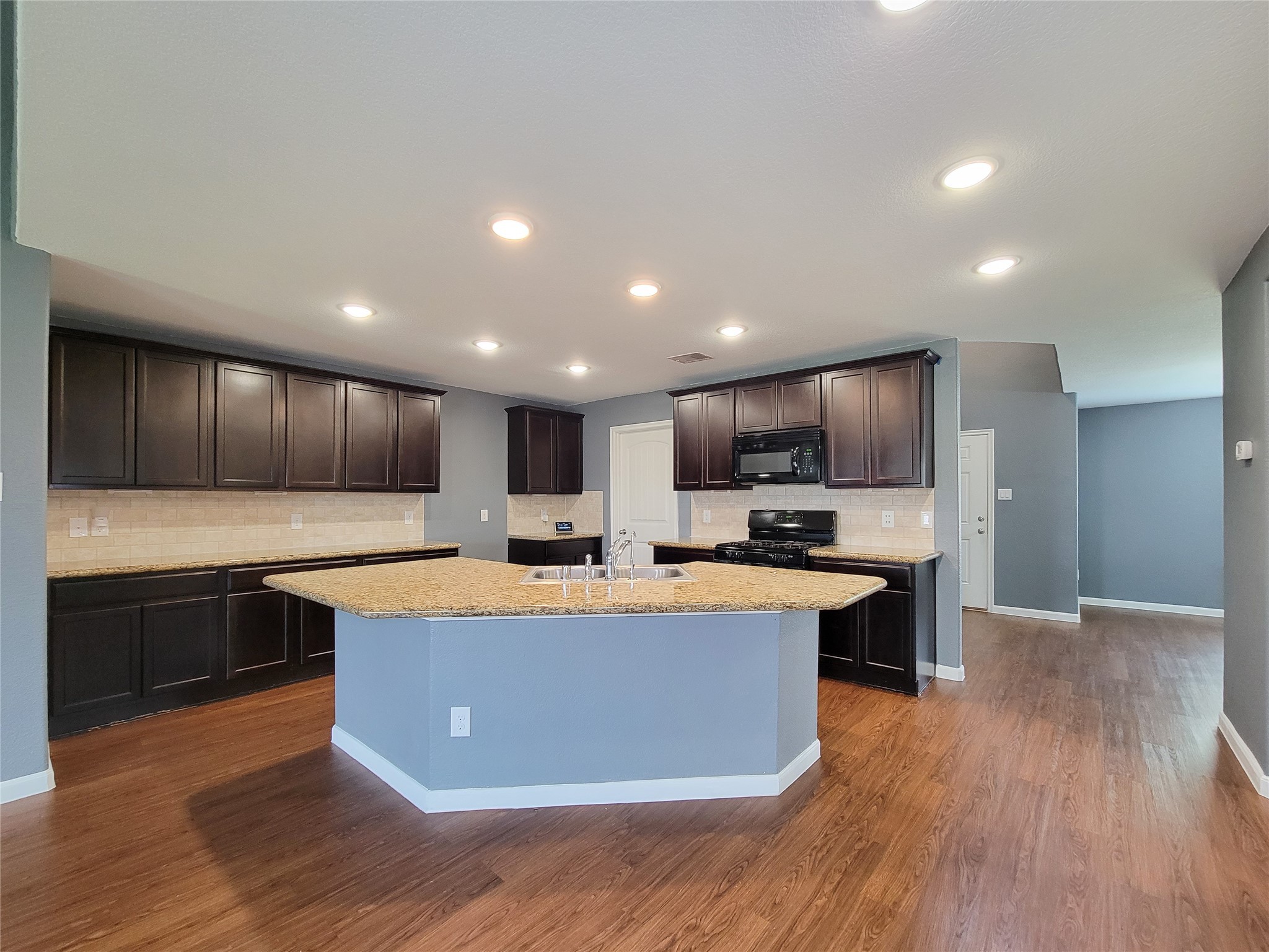 9726 Shimmering Lakes Drive Rosharon, TX 77583 - Photo 4 of 33 a kitchen with stainless steel appliances a sink a stove a refrigerator and a microwave