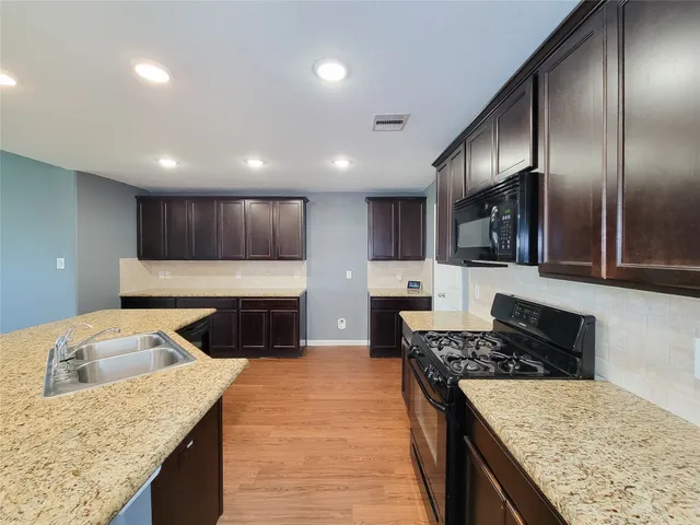 a kitchen with granite countertop stainless steel appliances and wooden cabinets