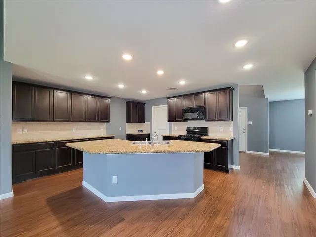 a kitchen with stainless steel appliances a sink a stove a refrigerator and a microwave