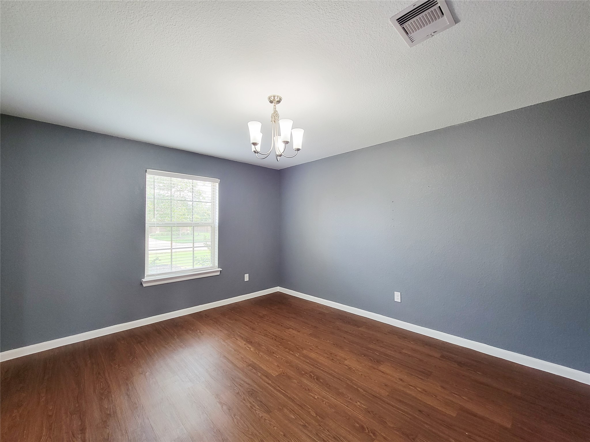 9726 Shimmering Lakes Drive Rosharon, TX 77583 - Photo 6 of 33 an empty room with wooden floor chandelier and windows