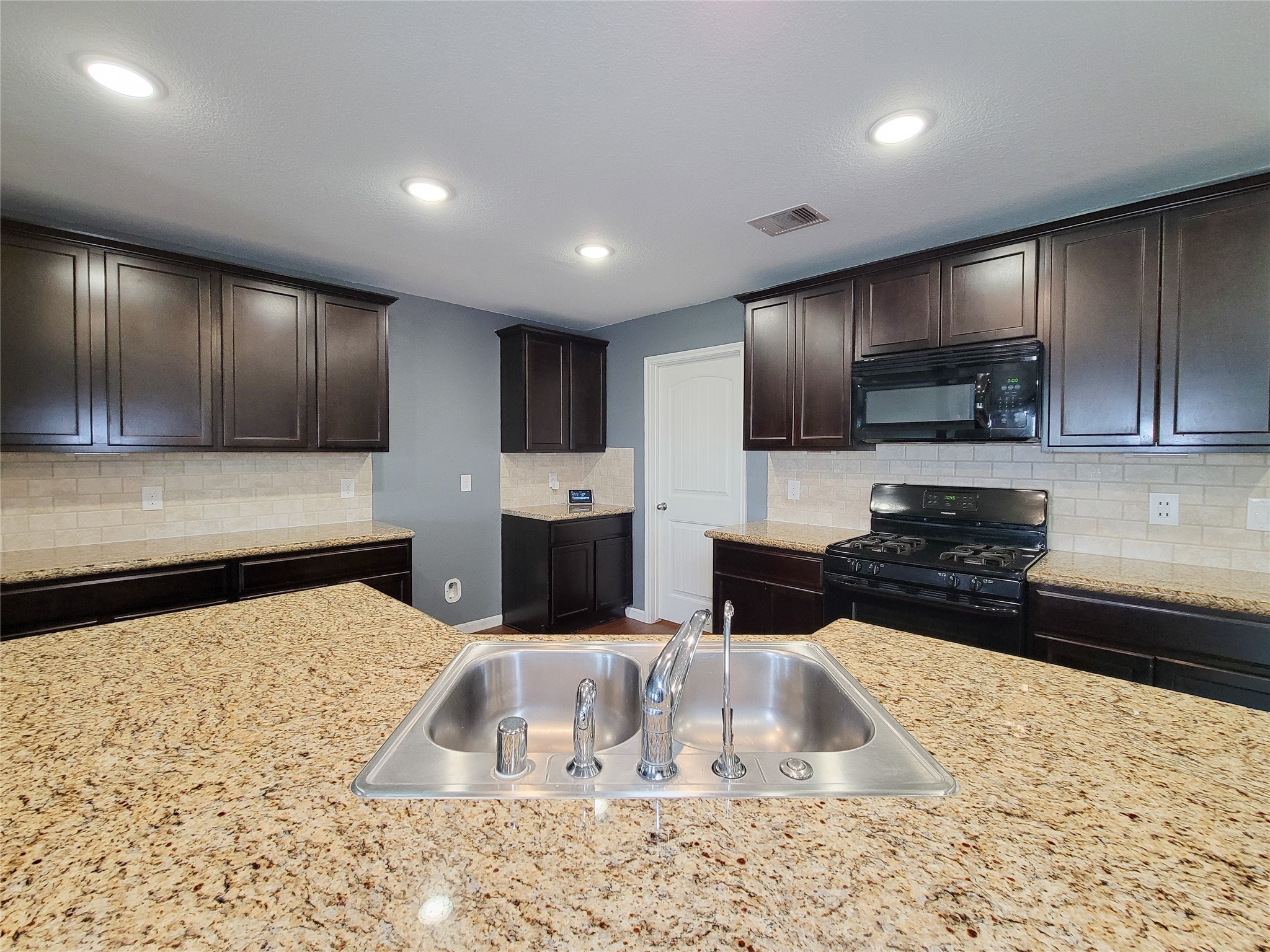 9726 Shimmering Lakes Drive Rosharon, TX 77583 - Photo 7 of 33 a kitchen with kitchen island granite countertop wooden cabinets a stove a oven and a sink