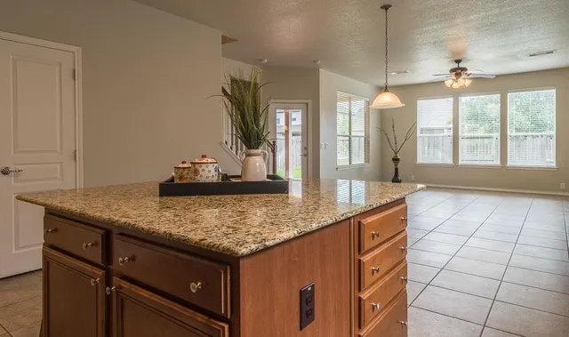 a kitchen with kitchen island granite countertop a sink a counter top space and cabinets
