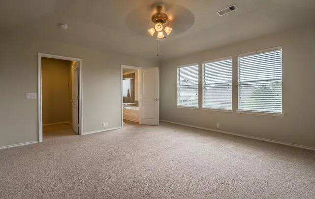 a view of a livingroom with furniture a ceiling fan and windows