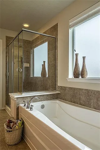 a spacious bathroom with a tub sink and mirror