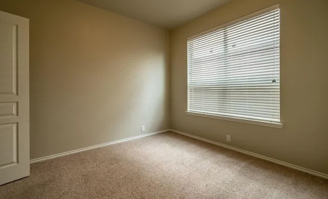 an empty room with closet and mirror