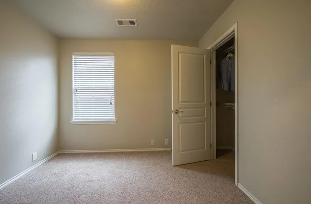 a view of a livingroom with a chandelier fan and windows