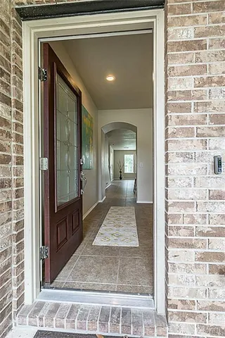 a view of a hallway with wooden floor and a living room