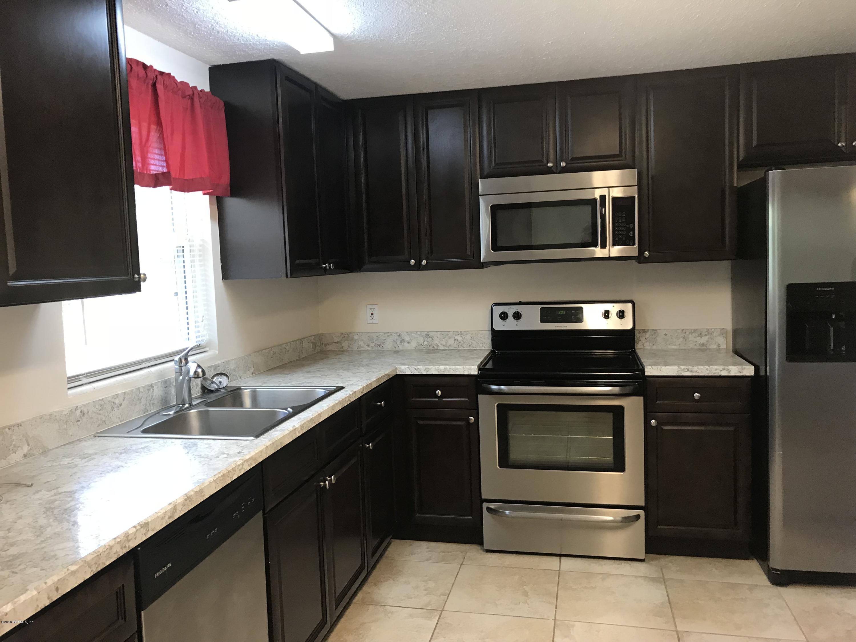 10640 Tulsa Road Jacksonville, FL 32218 - Photo 5 of 34 a kitchen with a sink stove and microwave