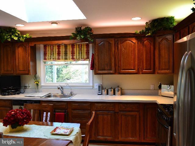 2106 Thomas View Road Reston, VA 20191 - Photo 22 of 29 a kitchen with stainless steel appliances granite countertop a sink dishwasher stove and cabinets with wooden floor