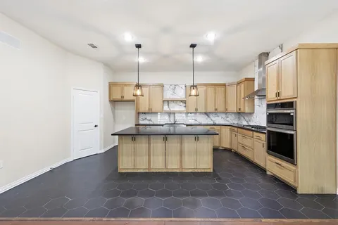 a kitchen with stainless steel appliances a stove a sink and white cabinets