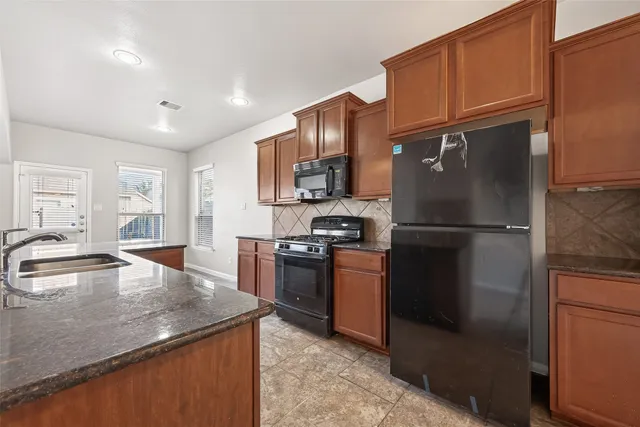 a kitchen with stainless steel appliances granite countertop a stove a microwave and a sink