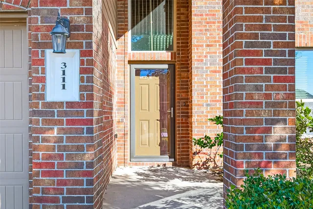 an empty room with wooden floor cabinet and windows