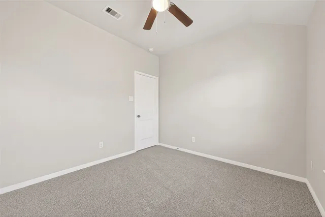an empty room with chandelier fan