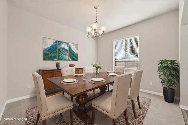 a view of an empty room with chandelier and wooden floor