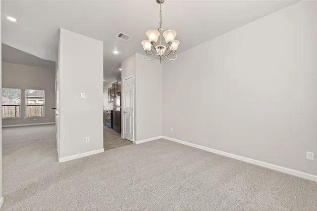a view of a livingroom with a chandelier fan and windows