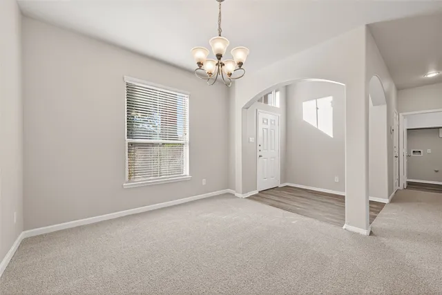 en empty room with windows and chandelier