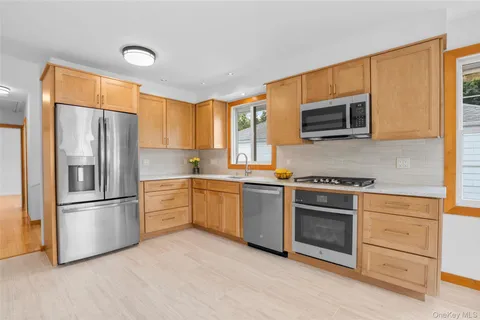 a kitchen with granite countertop a refrigerator stove and microwave