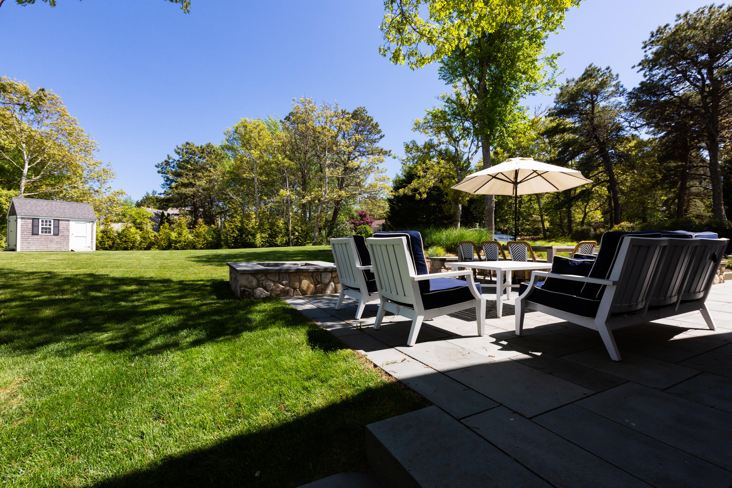 60 Tappan Drive Chatham, MA 02633 - Photo 7 of 46 a view of a patio with table and chairs under an umbrella