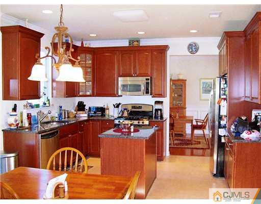 26 Carnation Road Monroe Township, NJ 08831 - Photo 2 of 10 a kitchen with stainless steel appliances granite countertop a refrigerator a stove top oven a sink and dishwasher