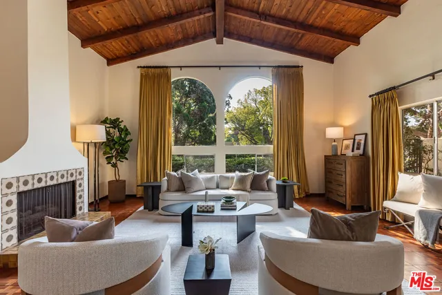 a living room with fireplace furniture and a large window