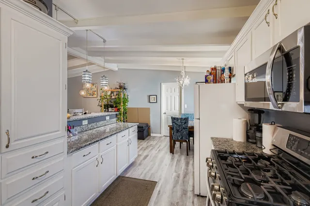 a kitchen with stainless steel appliances a stove a sink and a refrigerator