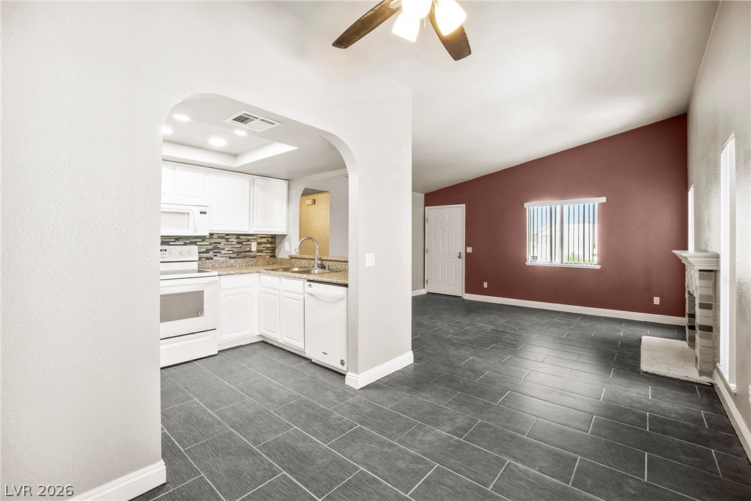 3311 Sunfish Drive, Unit D Henderson, NV 89014 - Photo 2 of 21 An open-concept living space with a contemporary kitchen and a living room featuring a cozy fireplace.