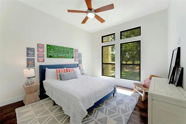 a bedroom with a bed a table and a large window