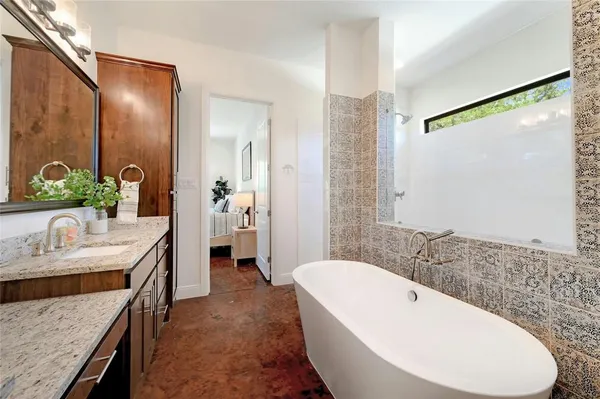 a spacious bathroom with a granite countertop tub sink and mirror
