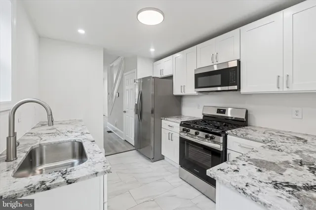 a kitchen with stainless steel appliances a stove a sink a microwave and cabinets