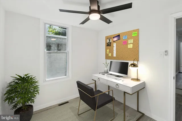 an empty room with a window and a fan