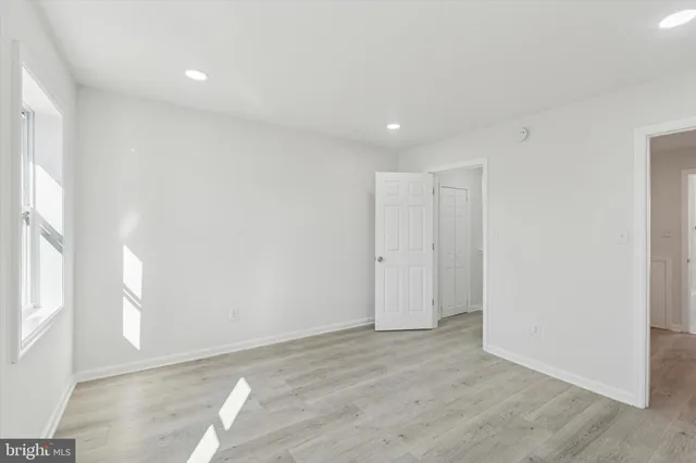 an empty room with wooden floor and entrance