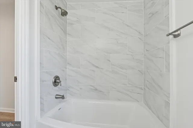 a view of hallway with window and wooden floor