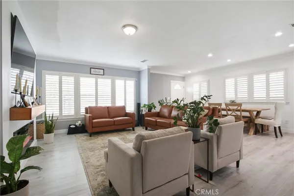 a living room with furniture potted plant and a large window