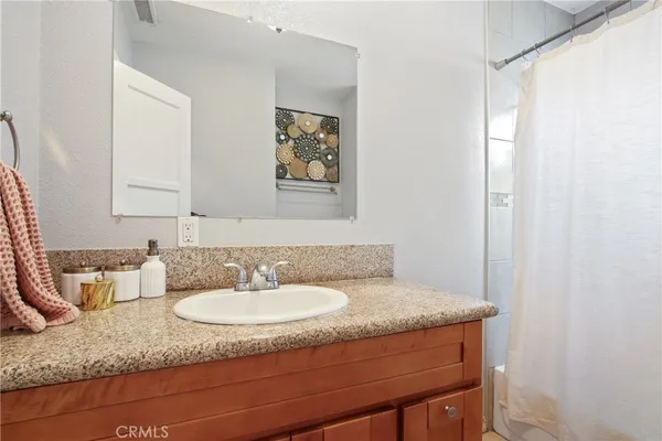 a bathroom with a granite countertop sink and a mirror
