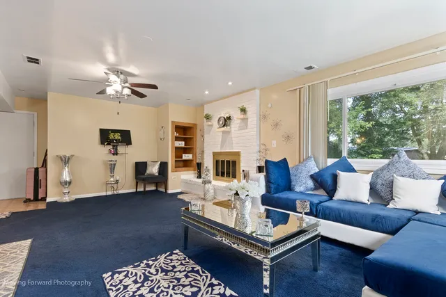 a living room with furniture ceiling fan and a window
