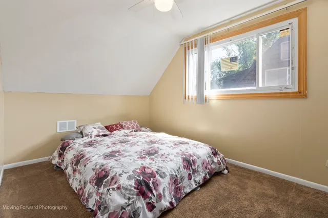 a bed sitting in a bedroom next to a window