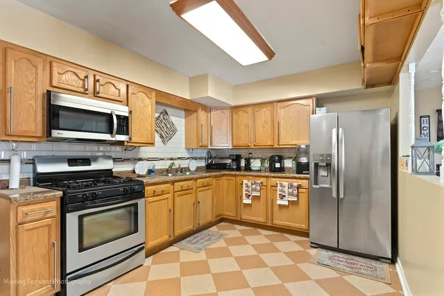 a kitchen with stainless steel appliances granite countertop a refrigerator a stove top oven a sink and dishwasher