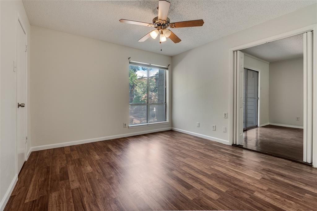 4859 Cedar Springs Road, Unit 254 Dallas, TX 75219 - Photo 4 of 14 an empty room with wooden floor chandelier fan and windows