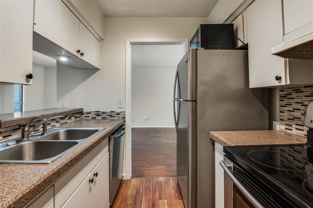 4859 Cedar Springs Road, Unit 254 Dallas, TX 75219 - Photo 9 of 14 a kitchen with granite countertop a sink stove and refrigerator