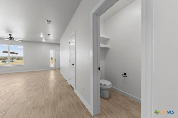 an empty room with fan and windows