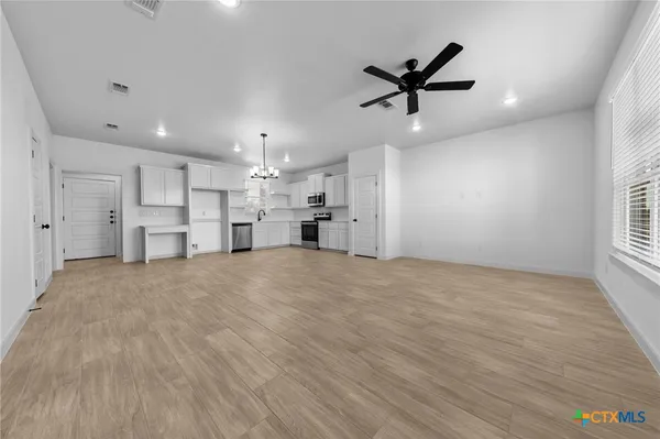 a view of empty room with wooden floor and windows