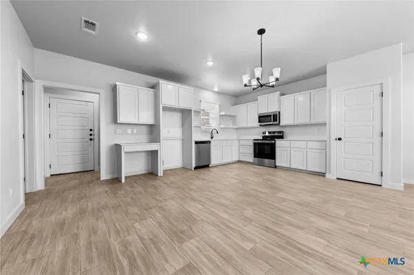 a view of kitchen with refrigerator and cabinets